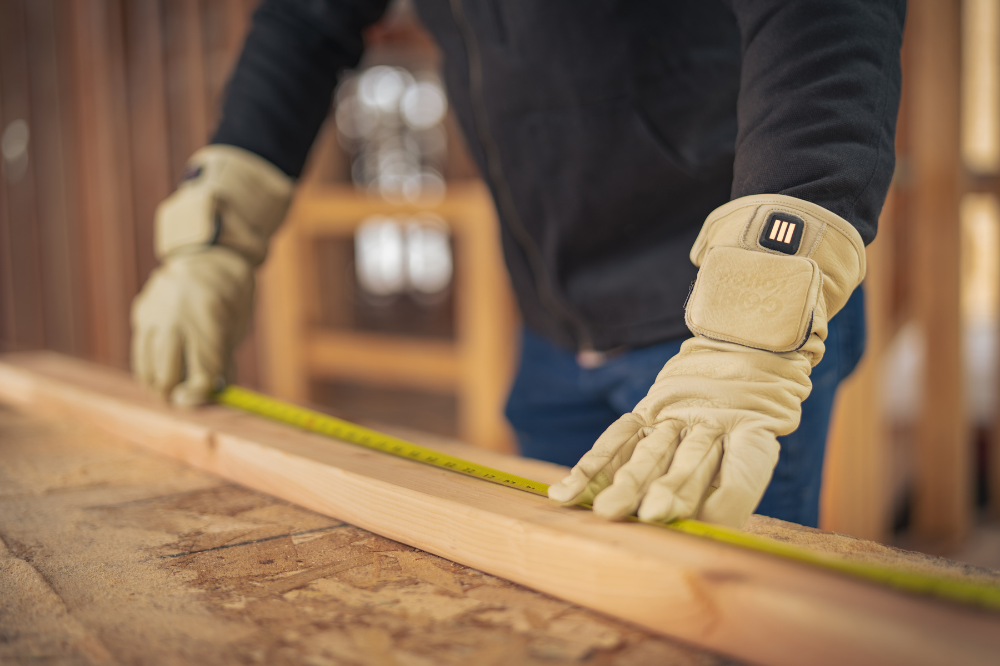 Man wearing Gobi Heat’s heated gloves while working outdoors, demonstrating full-finger warmth and flexibility.
