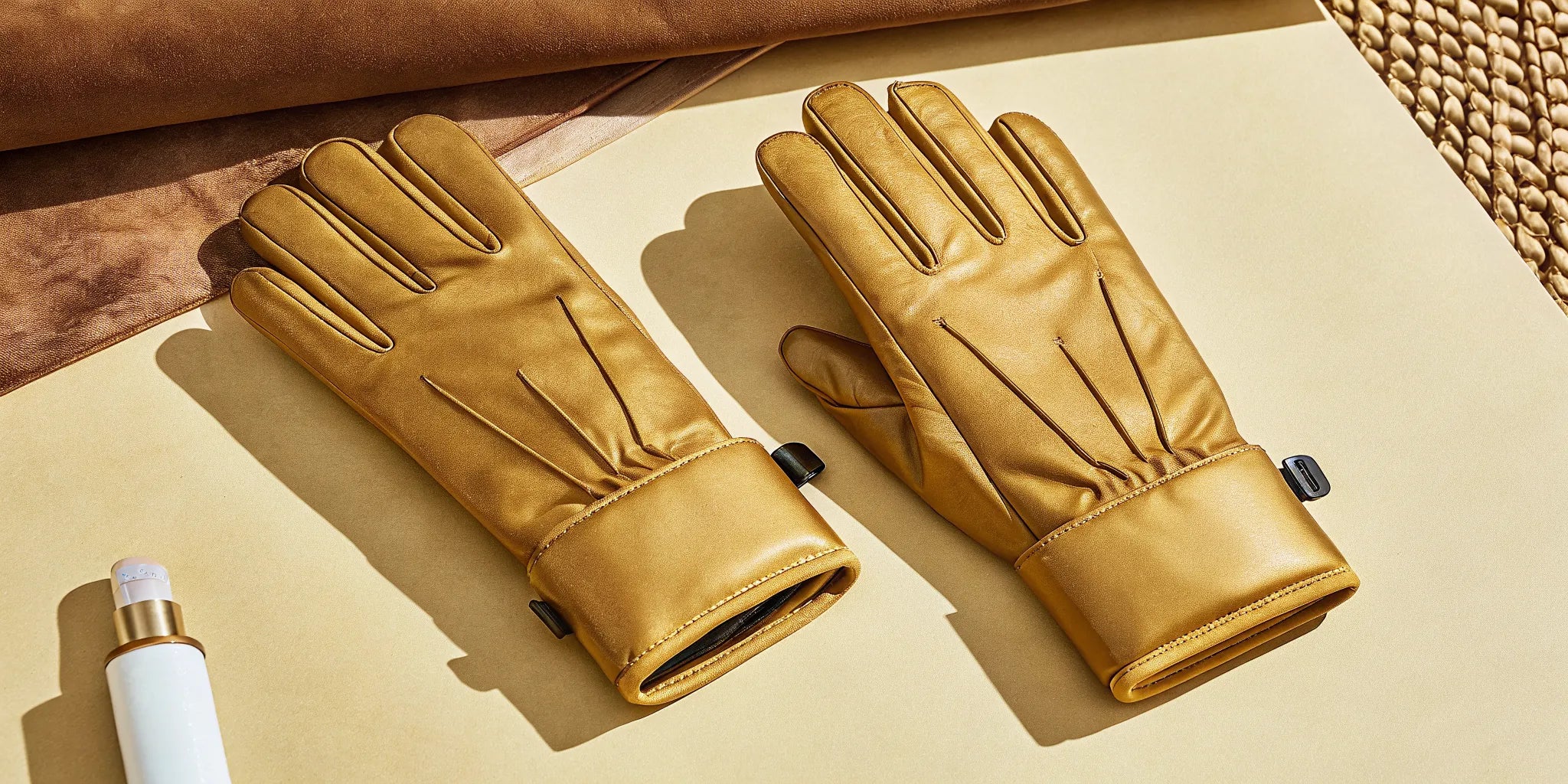 Rechargeable heated gloves made of tan leather with adjustable heat settings.