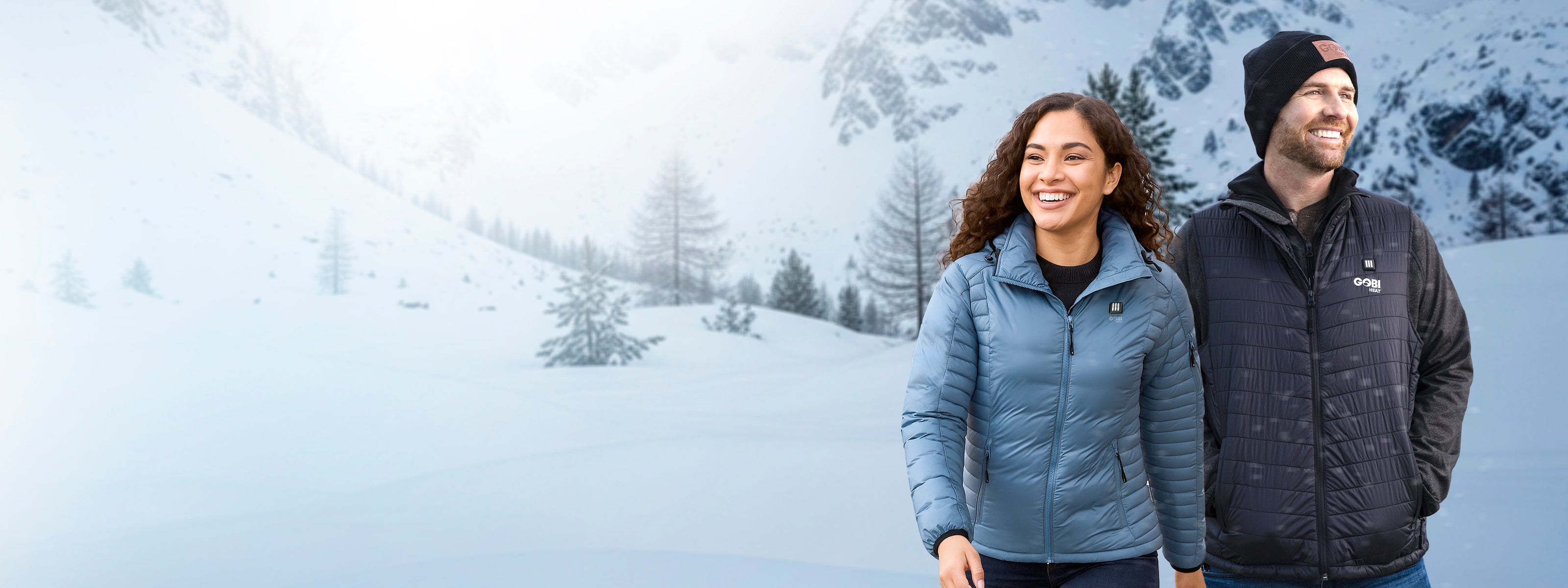 Two people standing in a snowy landscape wearing insulated jackets.