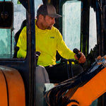 Man in a hi-vis yellow GOBI Helio UPF Sun Hoodie and trucker cap operating a forklift on a job site.