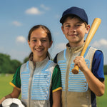Two children, a boy and a girl, standing outdoors with sports equipment against a clear sky wearing Gobi cooling vests